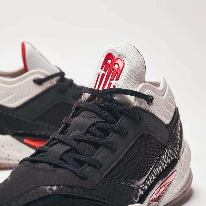 Detailed look white, red, and black New Balance shoes.